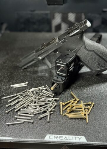 black Taurus tx22 sitting at an angle with striker pins under it scattered on the ground